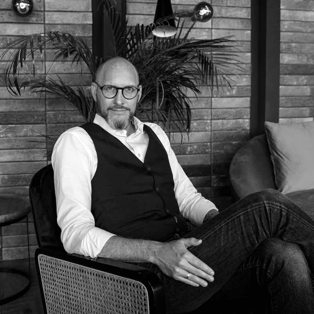 Black&White image of Oscar Karlsten sitting in a chair.